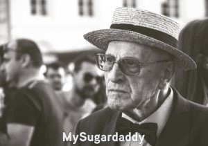 Seducir a un hombre: difícil  En la imagen se ve a un hombre mayor sin ningun tipo de expresión. Es díficil seducir a un hombre que no expresa nada. Sobre todo si tiene un traje puesto, lentes de sol y un sombrero. Un caballero que seguramente mantiene sus principios fiel a su lado.