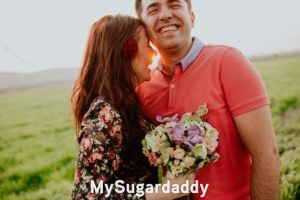 Cómo conversar con una Sugar Baby: Compartir sonrisas ¿Cómo conversar con una Sugar Baby?: En la imagen vemos a un hombre y una mujer que están teniendo un momento íntimo. Están compartiendo risas y se abrazan. Parece que tienen una muy buena conversación.