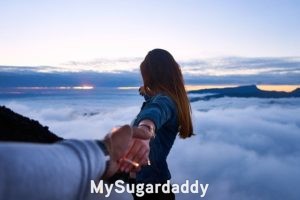 Sugar Baby busca: relacion apasionada Sugar Baby busca: En la imagen vemos una mujer mirando hacia el horizonte y sosteniendo la mano de su pareja. Simboliza el porvenir, que quiere lograr en su relación con el hombre a su lado.